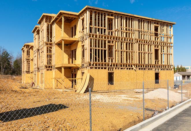 a close-up of temporary chain link fences enclosing a construction site, signaling progress in the project's development in Belle Glade